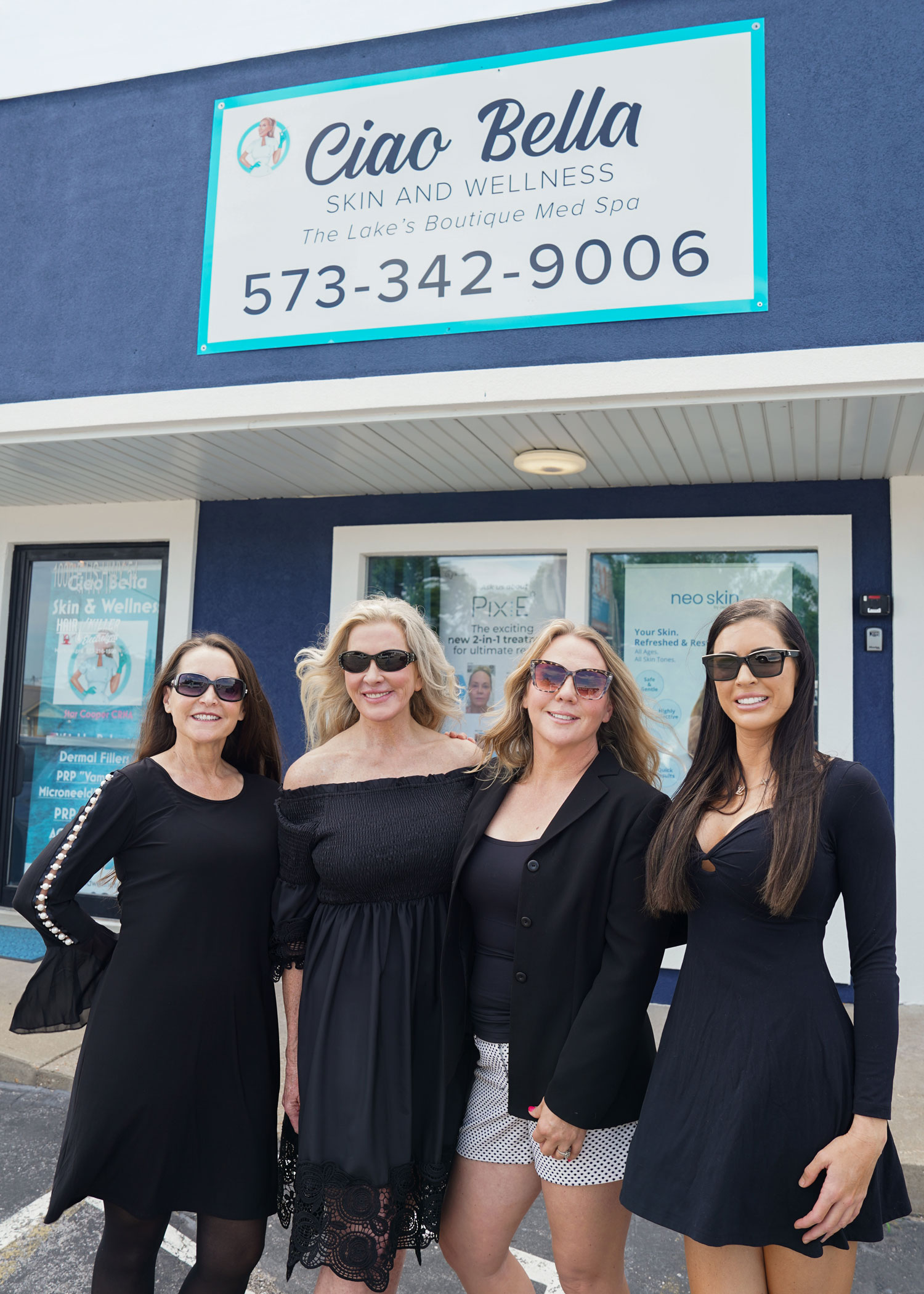 a group of people standing in front of a sign posing for the camera